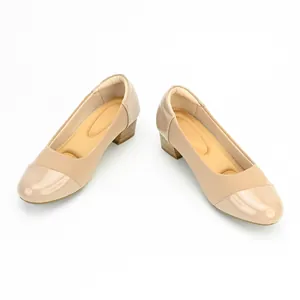 Close-up detail of beige women's chunky mid-heel pumps featuring a patent leather toe cap