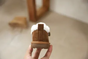 Close-up view of the heel and faux fur lining of a brown toddler snow boot.