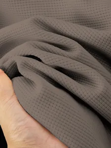 Close-up of waffle-knit fabric texture on men's winter jacket with honeycomb weave