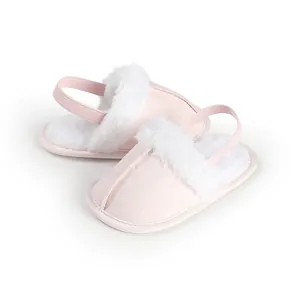 Vista de detalle de patucos rosa para bebé con ribete de pelo sintético blanco