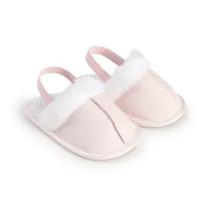 Vista detallada de zapatillas rosas para bebés con ribete de piel sintética blanca