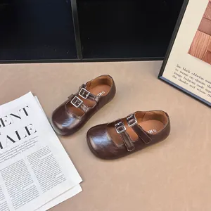 Dettaglio di scarpe Mary Jane marroni a punta tonda con doppio cinturino in velcro