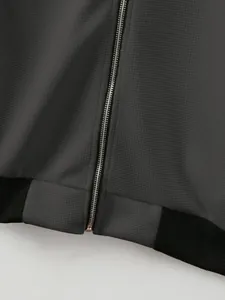 Detail view of men's grey waffle knit jacket with silver metal zipper and black rib