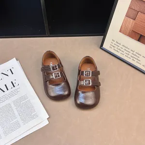 Dettaglio di eleganti scarpe Mary Jane marroni vintage con doppio cinturino e fibbie.