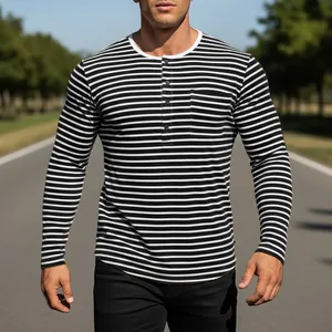 Detailed macro view of black and white striped long sleeve Henley shirt with chest pocket.