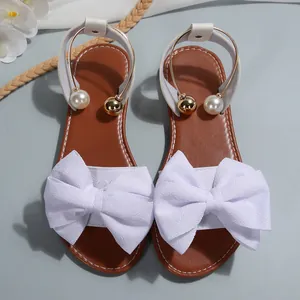 Sandales plates pour femmes avec grand nœud blanc et brides de cheville à perles