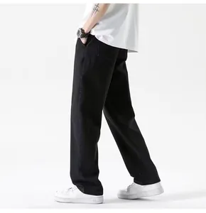 Close-up of men's loose straight-leg black jeans showing fabric texture and fit