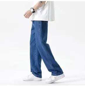 Dettaglio laterale di jeans blu larghi da uomo abbinati a scarpe da ginnastica bianche.