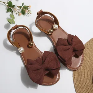 Sandales plates à la mode avec un grand nœud marron et un bracelet de cheville perlé