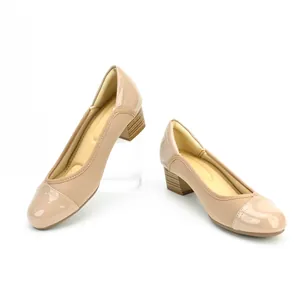 Side view detail of elegant beige block heel pumps with patent leather toe cap