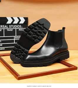 Gedetailleerd aanzicht van glanzende zwarte lederen Chelsea boots met dikke profielzolen.