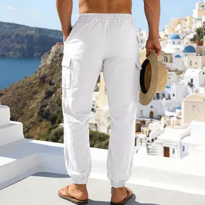 Weiße Herren Leinen-Cargohose mit elastischem Bund und Taschen in Strandnähe.