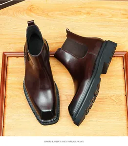 Detail van glanzende donkerbruine leren Chelsea-boots met grove profielzool