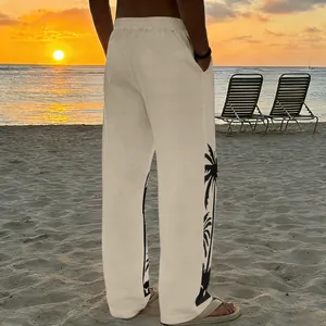 Detail of men's beige beach trousers with palm tree side print at sunset beach