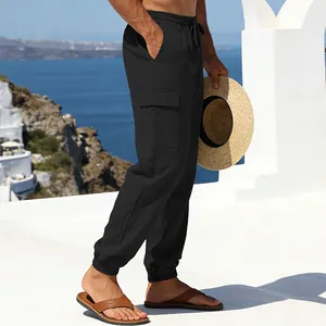 Schwarze Leinen-Cargohose für Herren mit Seitentaschen in sonniger Küstenumgebung.