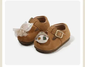 Cute brown toddler shoes with cartoon doll decorations and soft suede finish