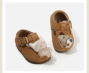 Detail view of brown suede toddler shoes with cute 3D cat and mouse doll decorations