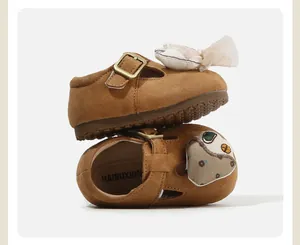 Close-up of adorable doll decorations on brown suede toddler shoes with soft soles