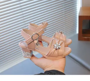Detailaufnahme der rosa Mädchen-Sandalen mit dekorativen Strassblumen und Absatz