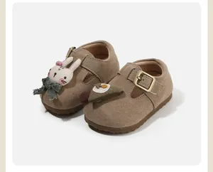 Close-up of brown suede toddler shoes with cute 3D rabbit and egg doll ornaments