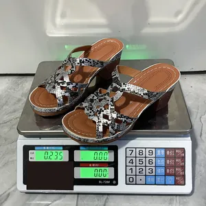 Women's snake print wedge sandals weighed on a digital scale for weight confirmation