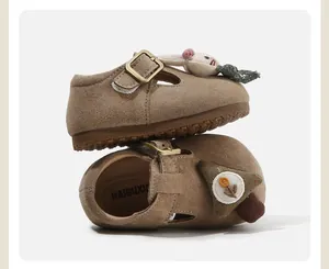 Detail view of toddler suede shoes featuring cute doll decorations and anti-slip soft soles