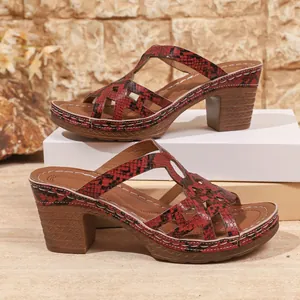 Side detail of women's red snakeskin platform sandals featuring a chunky block heel