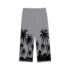 Detail of men's grey casual beach pants featuring black palm tree tropical print.