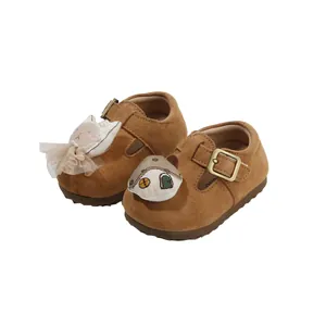 Cute brown suede toddler walking shoes with soft soles and cartoon doll decorations
