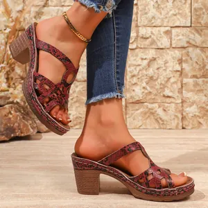 Detailed close-up view of women's platform sandals with red snake print and chunky heel.