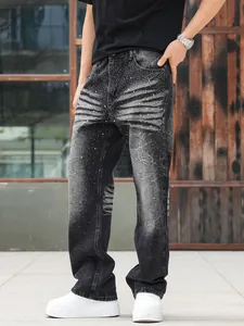 Detailed view of men's loose straight-leg washed black jeans with rhinestone accents.