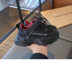 Gros plan de baskets pour enfants en mesh noir avec doublure rouge et semelle plateforme.