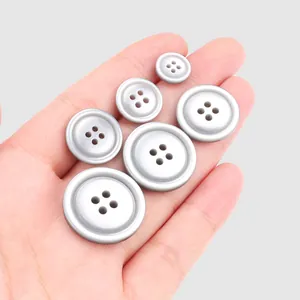 Premium silver four-hole resin buttons for high-end clothing displayed in multiple sizes