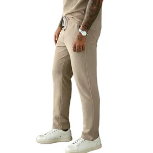 Detailed view of men's light brown corduroy pants with drawstring waist and straight fit.