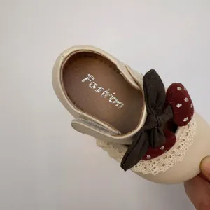 Detail view of toddler princess flat shoes with lace, bow, and cherry decoration