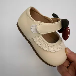 Detailed view of cream toddler Mary Jane shoes featuring delicate lace and cherry charm
