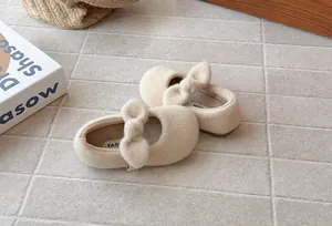 Detail of beige fuzzy girls' Mary Jane shoes with bow and soft fleece lining