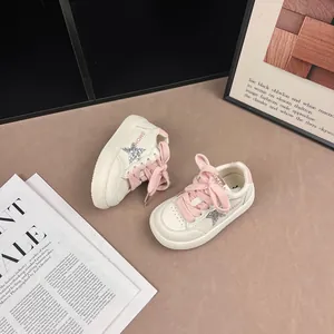 Detailed view of children's star sneakers with pink laces and silver glitter accents