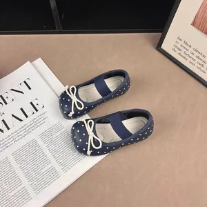 Detailed view of navy blue polka dot baby girl's Mary Jane shoes with white bow