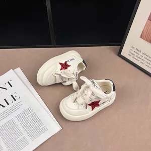 Detailed view of white children's sneakers with a sparkling red glitter star design