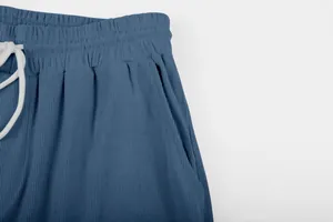 Close-up of blue corduroy trousers showing waistband and drawstring detail