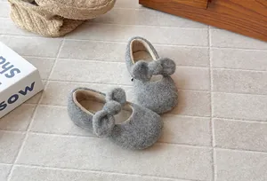 Detailed view of grey fuzzy fleece-lined winter shoes for girls with cute bow decoration
