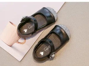 Dettaglio scarpe Mary Jane nere da bambina con punta glitterata argento e fibbia perla