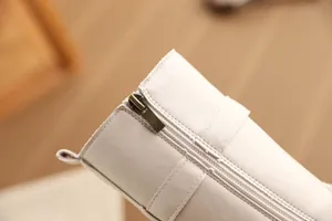 Detailansicht von Reißverschluss und Leder an beigen mittelhohen Mädchenstiefeln