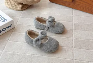 Close-up of elegant gray girls plush shoes featuring a bow detail and warm fleece lining