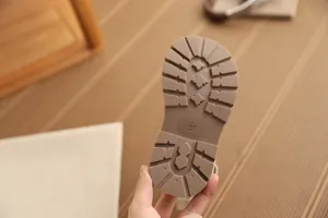 Detailaufnahme der strapazierfähigen braunen rutschfesten Sohle von Mädchenstiefeln im Vintage-Stil