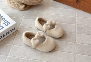 Close-up detail of beige furry Mary Jane shoes for girls with cute bow decoration