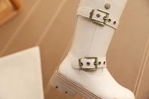 Detailansicht beige Mädchenstiefel mit doppelten Messingschnallen und dicker Sohle.
