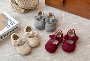 Close-up of girls' furry winter shoes in grey, beige and red with cute bow details.
