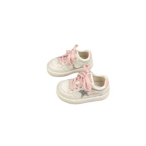 Stylish children's white sneakers featuring pink laces and a cute glitter star accent